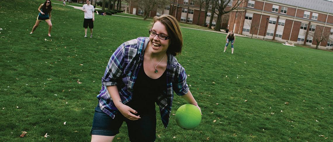 Student rolling kickball